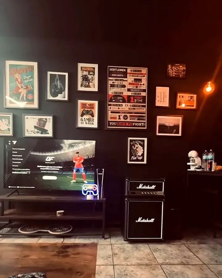 Zona de espera con cuadros, pantalla y amplificador Marshall